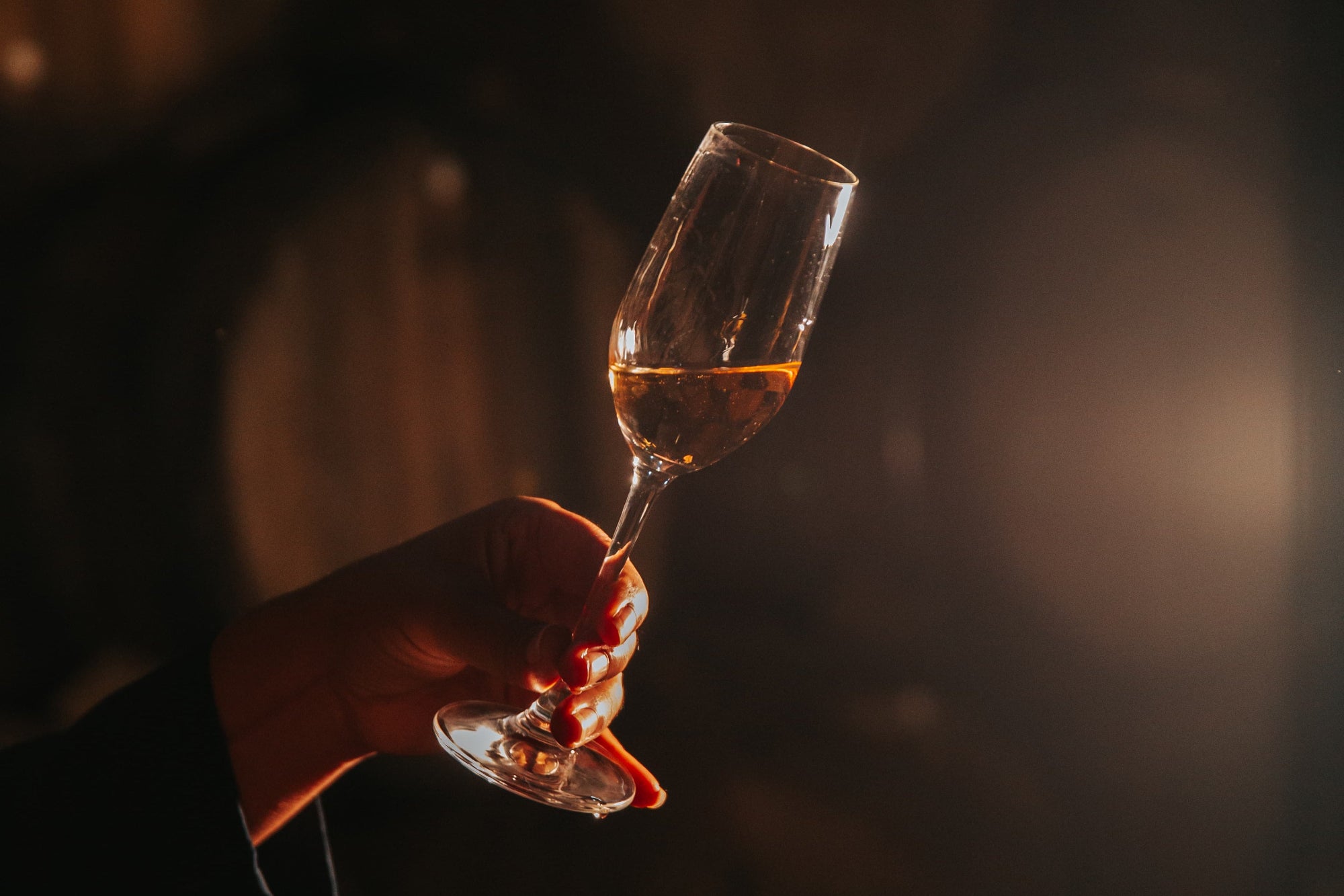 A glass of Quetzalli tequila held against the light